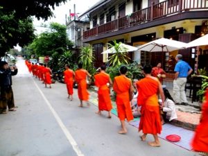 Monks in the early morning receiving alms from the locals. Luang Prabang.
